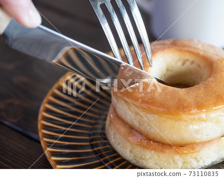 A donut-shaped scone with plenty of honey to eat with a fork and knife. A donut-shaped scone with plenty of honey to eat with a fork and knife. 73110835