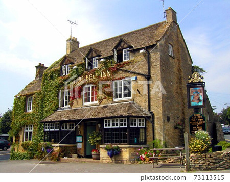 An old Cotswold inn with a honey-colored cityscape 73113515