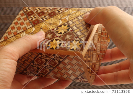 Hakone parquet, both hands of a woman touching a karakuri box Hakone parquet, both hands of a woman touching a karakuri box 73113598