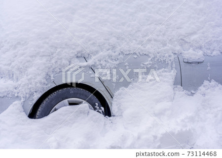 After heavy snowfall car covered totally with snow standing at city parking. After heavy snowfall car covered totally with snow standing at city parking. 73114468