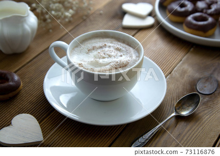 Cup of coffee,milk saucer and donuts, on wooden table with copy space. Cup of coffee,milk saucer and donuts, on wooden table with copy space. 73116876