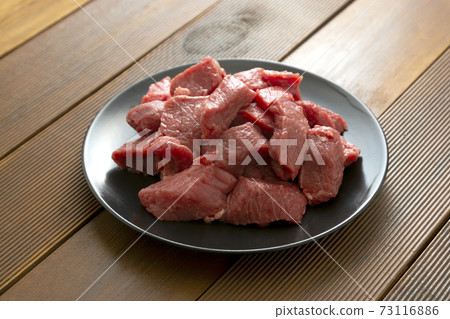 Beef uncooked raw steak on black plate, wooden board. Beef uncooked raw steak on black plate, wooden board. 73116886