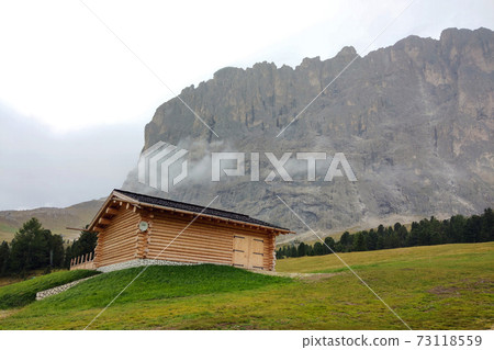 A small house against the backdrop of the Dolomites in Italy. 73118559
