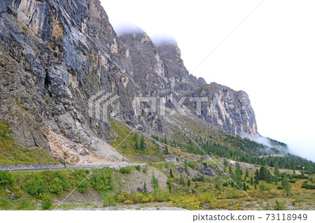 The peaks of the Dolomites in Italy are covered in fog. Early wet foggy morning. Beginning of autumn. Clean fresh air, lack of people. Selective focus. The peaks of the Dolomites in Italy are covered in fog. Early wet foggy morning. Beginning of autumn. Clean fresh air, lack of people. Selective focus. 73118949