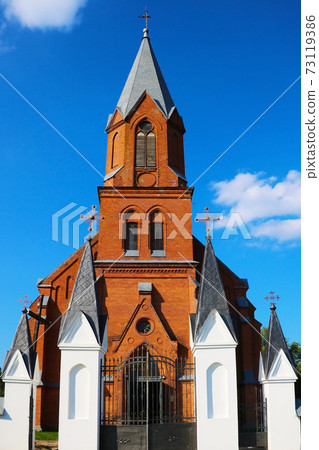 Old beautiful red brick church on a sunny day. 73119386