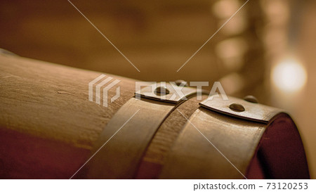 Old wine barrels in a wine cellar. Stacked up wine bottles in the cellar, dusty but tasty. Old wine barrels in a wine cellar. Stacked up wine bottles in the cellar, dusty but tasty. 73120253