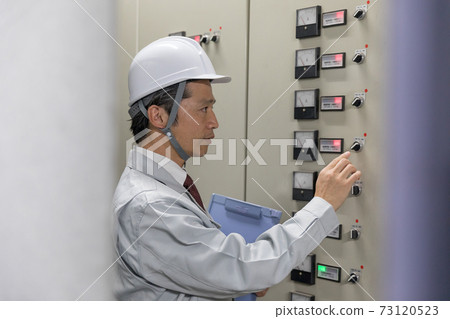 Middle man operating the switchboard in the factory facility Middle man operating the switchboard in the factory facility 73120523