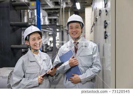 Workers working at factory facilities 73120545