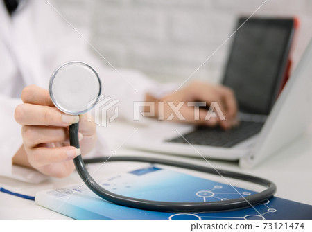 Medical stethoscope placed on the doctor's table 73121474