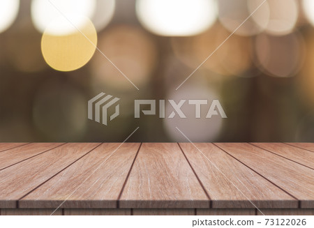 Empty wooden table top with lights bokeh on blur restaurant background. 73122026