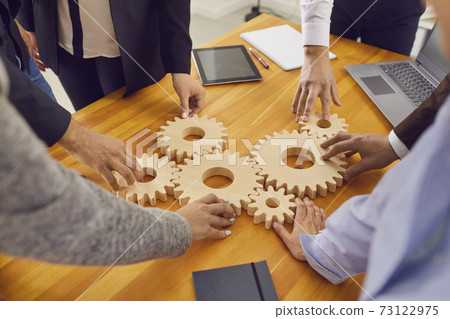 Company workers joining gear wheels as metaphor for effective teamwork and finding working solutions Company workers joining gear wheels as metaphor for effective teamwork and finding working solutions 73122975