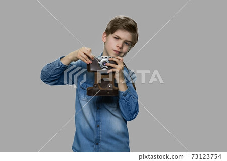Little boy using film camera on gray background. 73123754