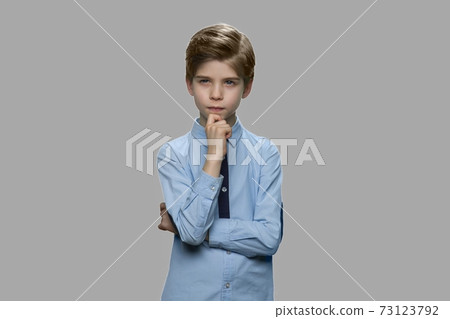 Thoughtful preteen boy on gray background. Thoughtful preteen boy on gray background. 73123792