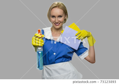Housekeeper in uniform holding cleaning supplies. 73123893