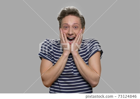 Portrait of emotional teen boy on gray background. 73124846
