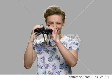 Teen boy looking through binoculars. Teen boy looking through binoculars. 73124987