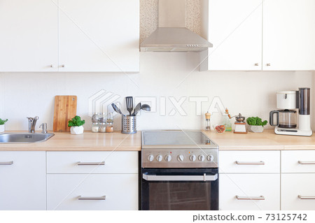 Scandinavian classic minimalistic kitchen with white and wooden details. Modern white kitchen clean contemporary style interior design. 73125742