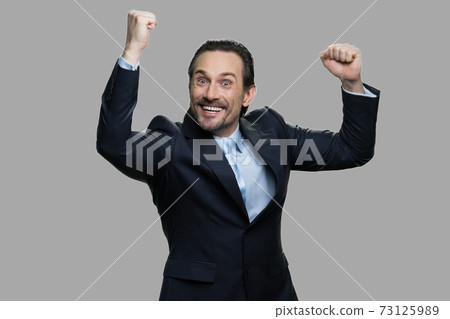 Lucky successful businessman clenched his fists. Lucky successful businessman clenched his fists. 73125989