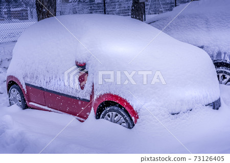 After heavy snowfall car covered totally with snow standing at city parking. After heavy snowfall car covered totally with snow standing at city parking. 73126405