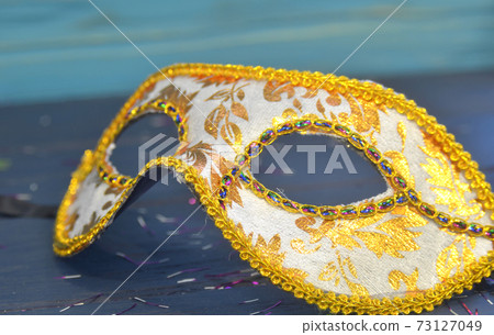 Mardi gras mask and beads on a wooden background. Madi Gras carnival accessories, confetti, Festive, venetian or carnivale mask. Masquerade celebration concept Mardi gras mask and beads on a wooden background. Madi Gras carnival accessories, confetti, Festive, venetian or carnivale mask. Masquerade celebration concept 73127049