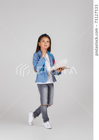 cute little girl holding tape measure and notebook 73127533