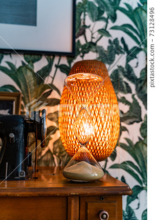 Sewing machine, hourglass and lamp with wallpaper in floral tropical pattern 73128496