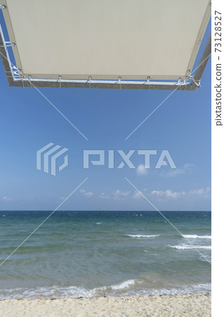 Beach umbrella against the blue clear sky on the beach 73128527