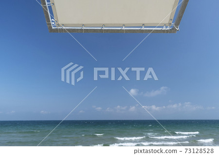 Beach umbrella against the blue clear sky on the beach 73128528