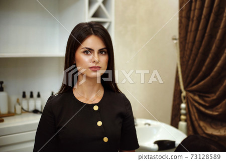 Beautiful portrait of pretty young caucasian woman hairdresser standing in the beauty salon 73128589