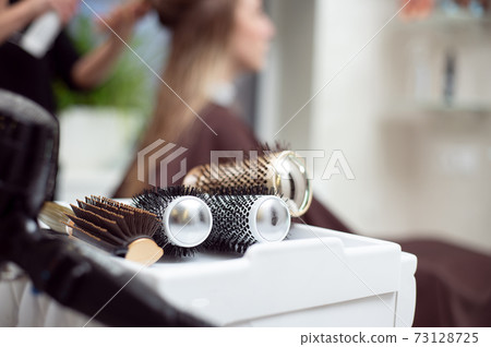 Cropped view of professional hairdresser tools . Closeup of round brushes on the background of a hairdresser while working 73128725