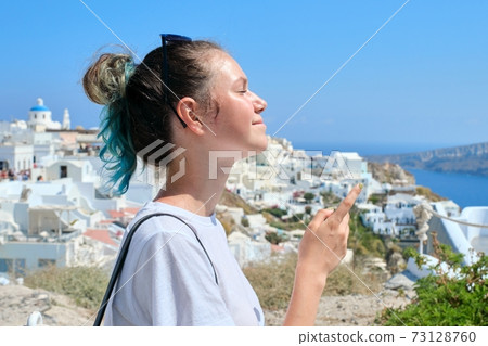Teenager girl resting on Greek island Santorini, looking away Teenager girl resting on Greek island Santorini, looking away 73128760
