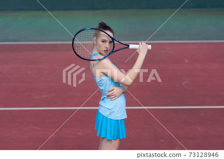 Sexy girl tennis player holding tennis racket on the court. Young woman is playing tennis. Sexy girl tennis player holding tennis racket on the court. Young woman is playing tennis. 73128946