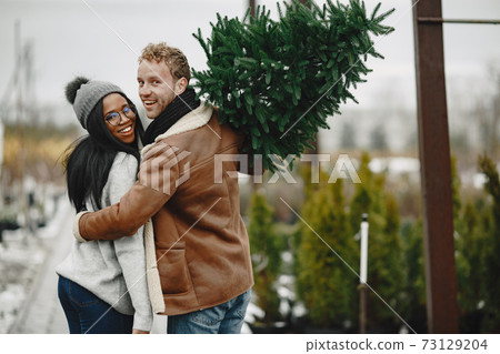 Mixed couple choosing a christmas tree 73129204