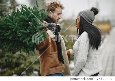 Mixed couple choosing a christmas tree 73129209