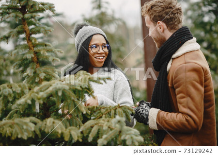 Mixed couple choosing a christmas tree 73129242