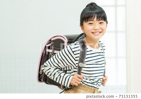 Elementary school girl carrying a school bag Elementary school girl carrying a school bag 73131355