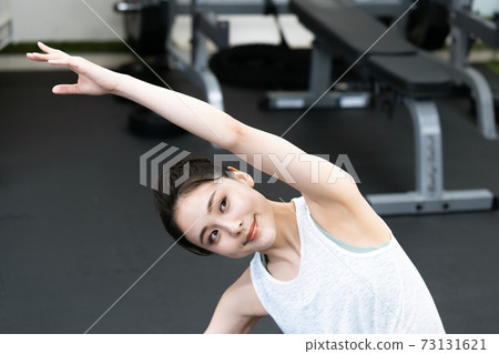 舒展在健身房裡的年輕女子 73131621