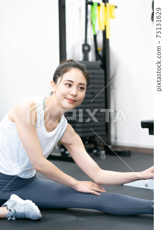 Young woman stretching in the gym Young woman stretching in the gym 73131629