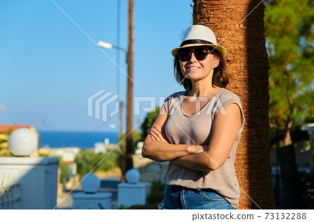 Portrait of mature beautiful smiling woman on vacation, summer tropical landscape Portrait of mature beautiful smiling woman on vacation, summer tropical landscape 73132288