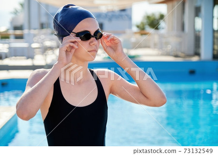 Portrait of teenage girl swimmer, outdoor swimming pool background 73132549