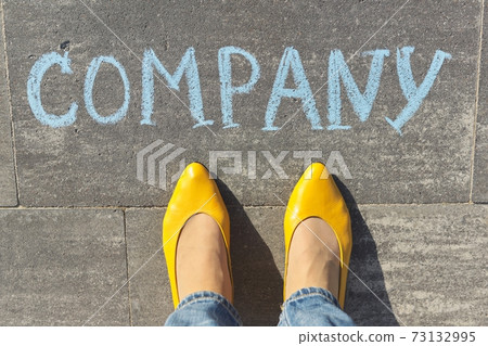 Company concept, top view on woman legs and text written in chalk on gray sidewalk 73132995