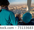 Brother inside the London Eye looking at London city view 73133683