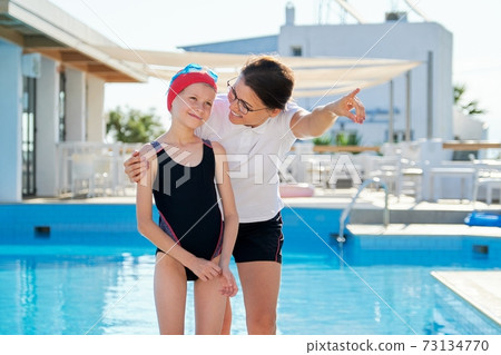 Talking mother and child swimmer, outdoor swimming pool background 73134770