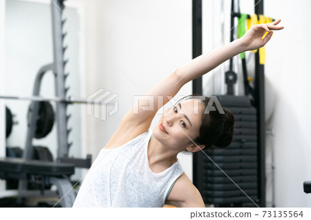 舒展在健身房裡的年輕女子 舒展在健身房裡的年輕女子 73135564