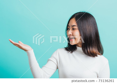 woman smiling makeup showing product on blank hand woman smiling makeup showing product on blank hand 73136261