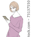 A woman smiling with a smartphone in one hand 73137550