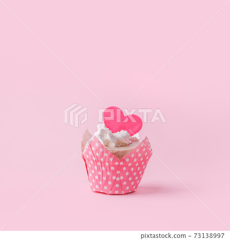 Valentines cupcake with a pink heart shaped cake pick on a pink background, Saint Valentine romance monochrome concept, sweet food, birthday, girl seasonal holiday party, flyer, invitation Valentines cupcake with a pink heart shaped cake pick on a pink background, Saint Valentine romance monochrome concept, sweet food, birthday, girl seasonal holiday party, flyer, invitation 73138997