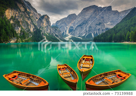 Beautiful mountain lake with wooden boats in the Dolomites,Italy Beautiful mountain lake with wooden boats in the Dolomites,Italy 73139988