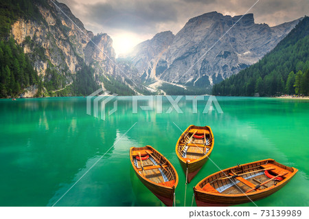 Stunning mountain lake with wooden boats in the Dolomites,Italy Stunning mountain lake with wooden boats in the Dolomites,Italy 73139989