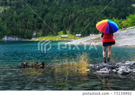 Young woman hiker standing on the stones,Gosausee,Salzkammergut,Austria Young woman hiker standing on the stones,Gosausee,Salzkammergut,Austria 73139992